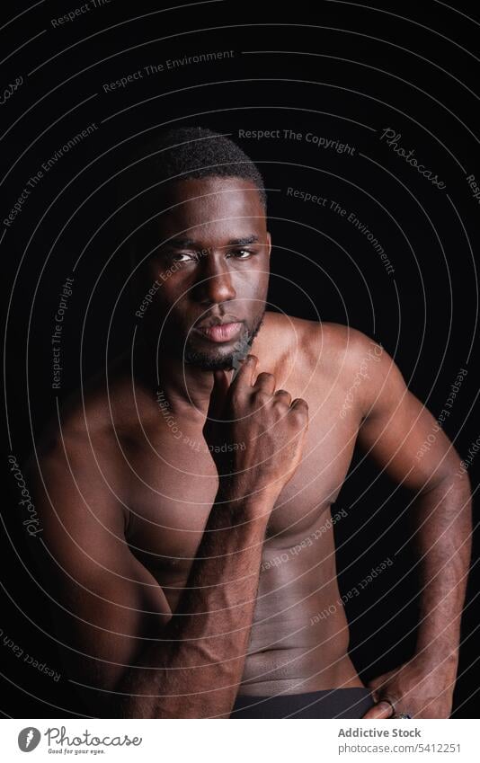 Serious black man with naked torso looking at camera sportsman athlete muscular shirtless portrait macho confident masculine strong male ethnic muscle model