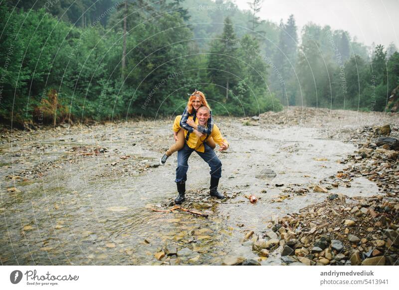 Playful happy handsome couple having while walking in woods. tourists in the mountains. Adventure in nature concept. couple in the mountains active relationship