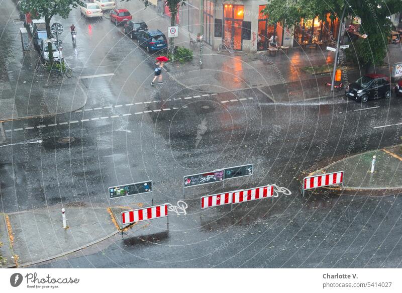 Summer thunderstorm - woman runs across the street with red umbrella Rain summer thunderstorms Bad weather Exterior shot Wet Weather Colour photo one person