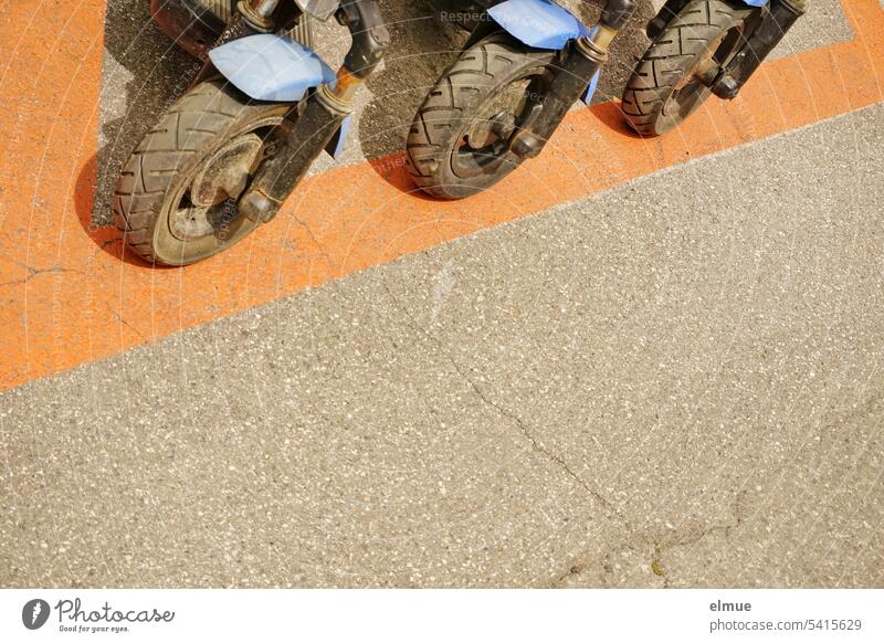 Front wheels of three parked e-scooters e-roller electric scooter switch off eMobility Lifestyle Means of transport Electric Load Blog Road traffic Technology