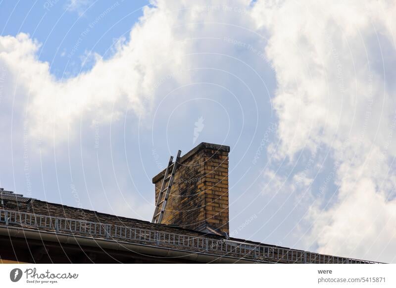 A ladder leans on a tiled roof against a chimney in Lichtenfels Franconia Germany Ladder Main basket maker basket weaver basket weaving school building