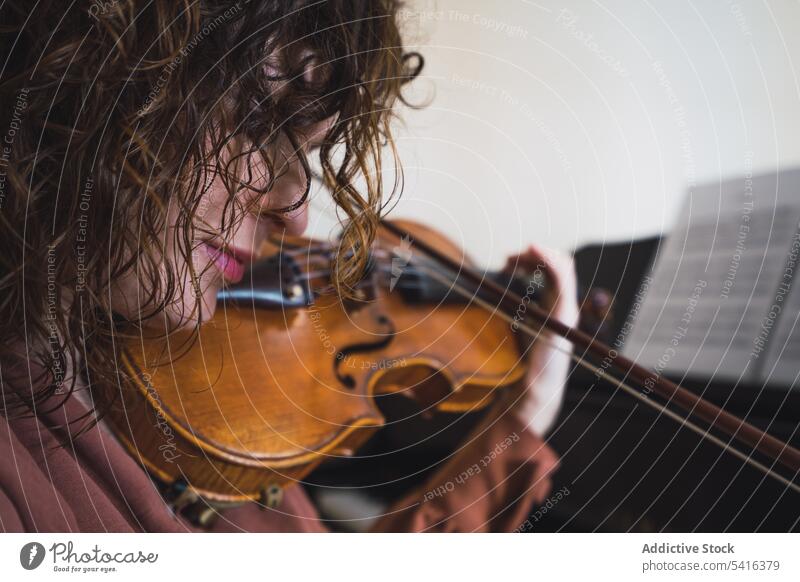 Pregnant woman playing on violin near piano in room pregnant musician attractive young curly hair beautiful closed eyes female belly sitting lifestyle relax