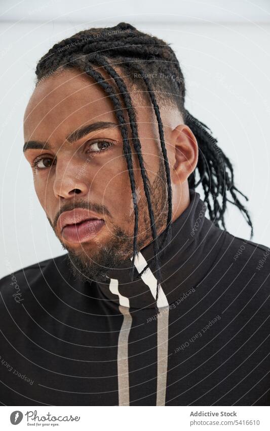 Ethnic male looking at camera man ethnic hairstyle cornrows braided young thoughtful african american black person handsome portrait positive attractive relaxed