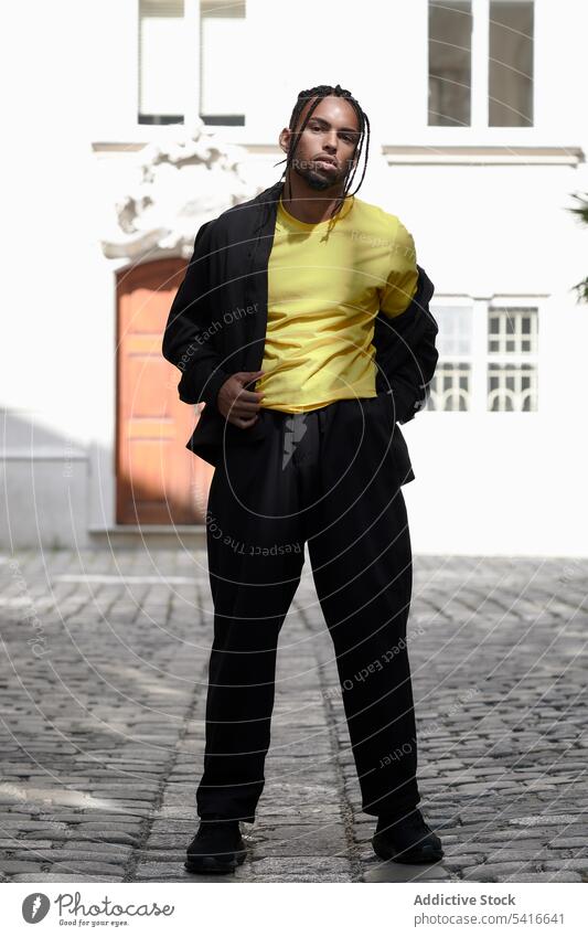 African American male standing on the street man ethnic braided arms crossed young african american person handsome attractive displeased pensive thoughtful