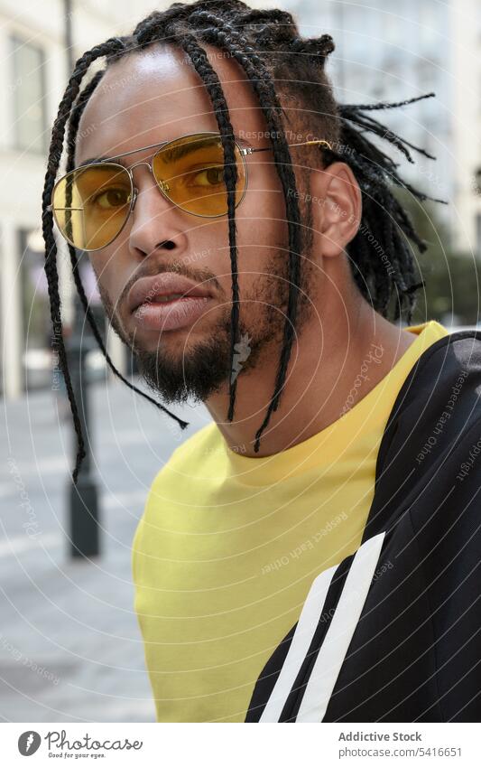 African American male standing with arms crossed man ethnic braided young african american person handsome attractive displeased pensive thoughtful serious