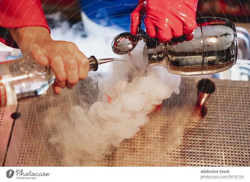 Bartender in red gloves making smoking cocktail bartender alcohol pouring nightclub stirring preparing mixing bottle barman uniform ice cubes glass drink