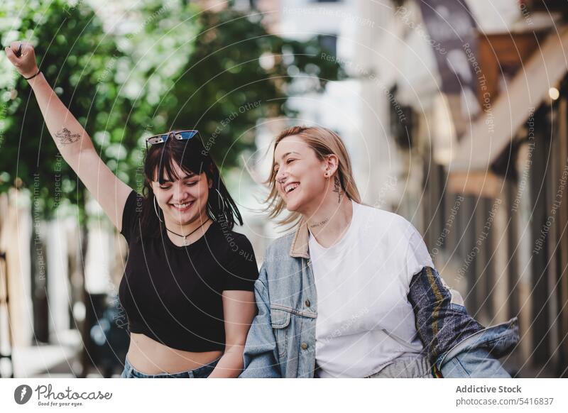 Lesbian couple with LGBT flag walking on street lesbian lgbt happy waving city young together women casual homosexual pride equality alternative relationship