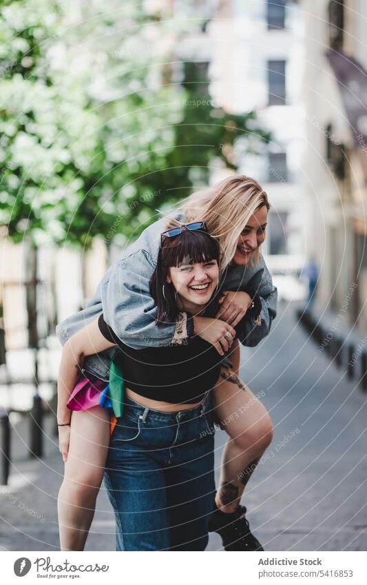 Happy lesbian couple having fun on street lgbt hugging lifting piggyback happy city young together women casual homosexual pride lap equality alternative