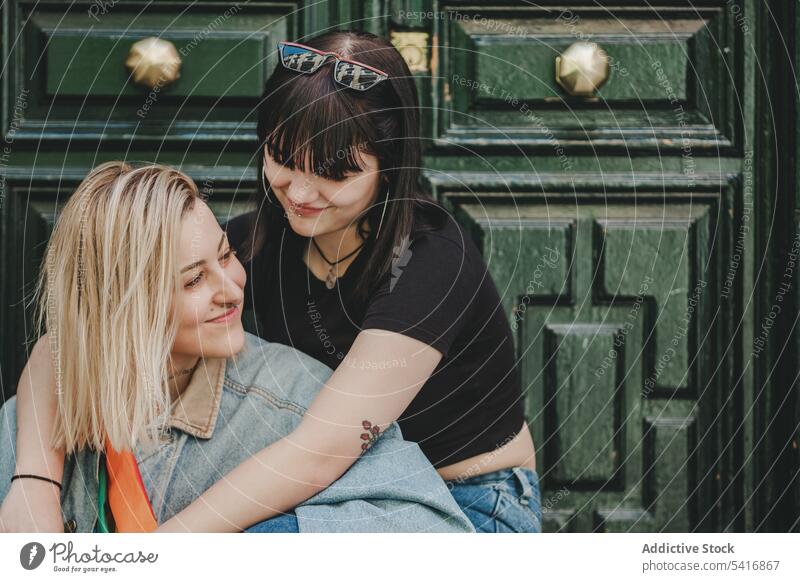 Lesbian couple sitting near door feelings happy smile hugging town beautiful alternative together homosexual women lifestyle relationship leisure relax intimate