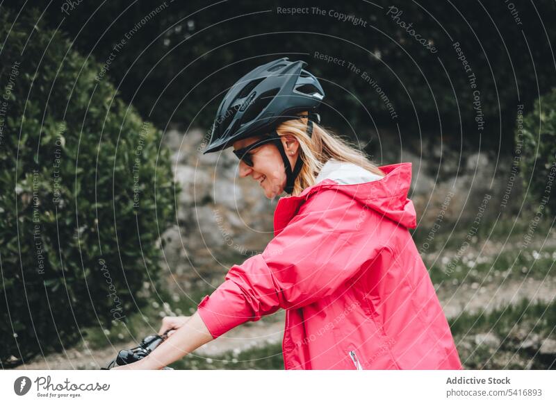 Smiling female riding bicycle woman road young person cheerful active sportive cyclist smiling enjoying lifestyle bike travel transport adventure helmet