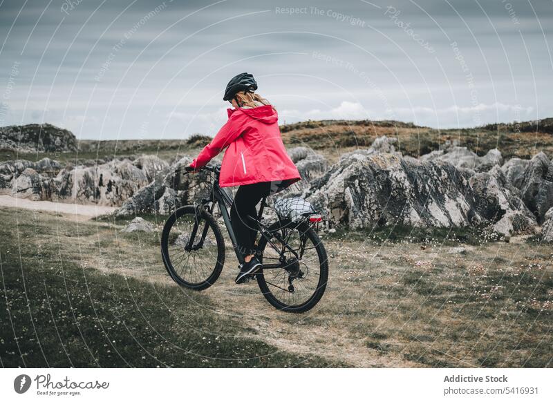 Female cyclist riding on mountain road woman bicycle helmet rocky landscape female adult person active sportive alone cycling lifestyle bike travel adventure