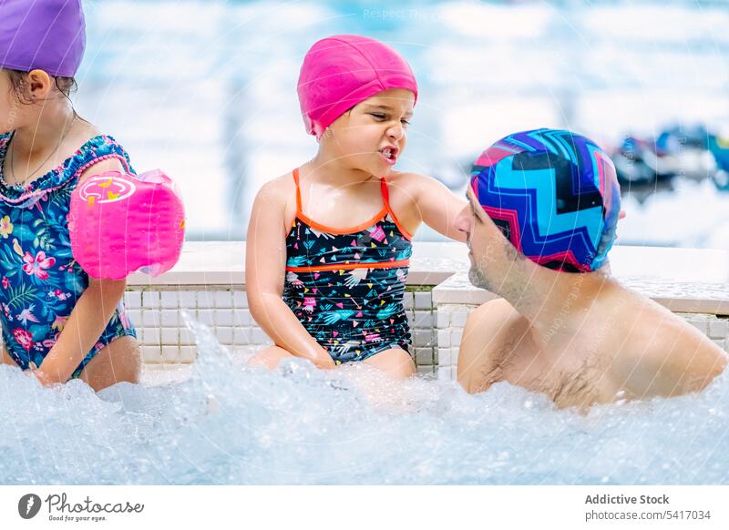 Family relaxing in bubbling pool family swimming bubbles parents daughters talking together amusement park water fun leisure rest girls kids children siblings