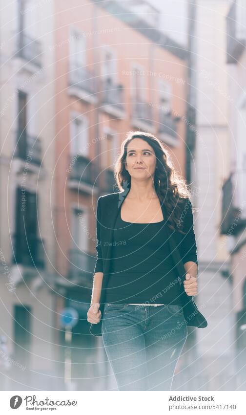 Young female walking on the street woman young person attractive brunette beautiful pretty long hair casual relaxed happy cheerful stylish smiling leisure