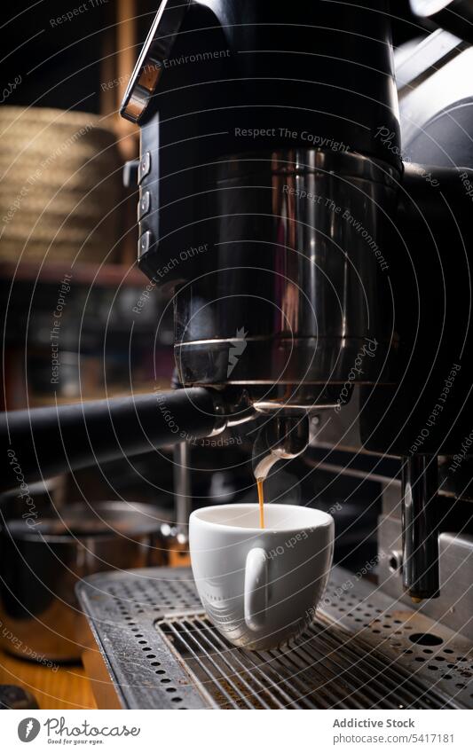 Barista making coffee using a coffee maker cafe gourmet shop holding cappuccino machine service equipment prepare espresso work professional black mug employee