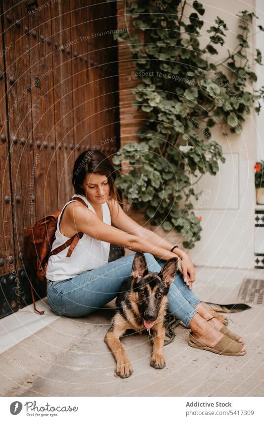 Woman with cute shepherd woman kiss street happy together dog domestic breed city companion owner animal beautiful urban pavement pet friend casual style