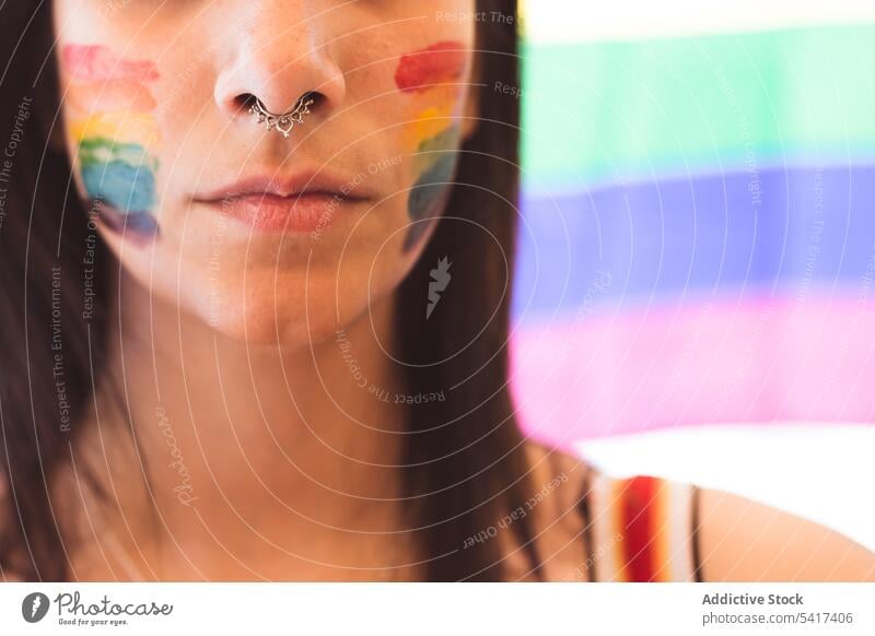 Brunette woman with LGBT symbol on face straightening hair beautiful lgbt attractive young pretty sensual serious freedom equality rights female tolerance