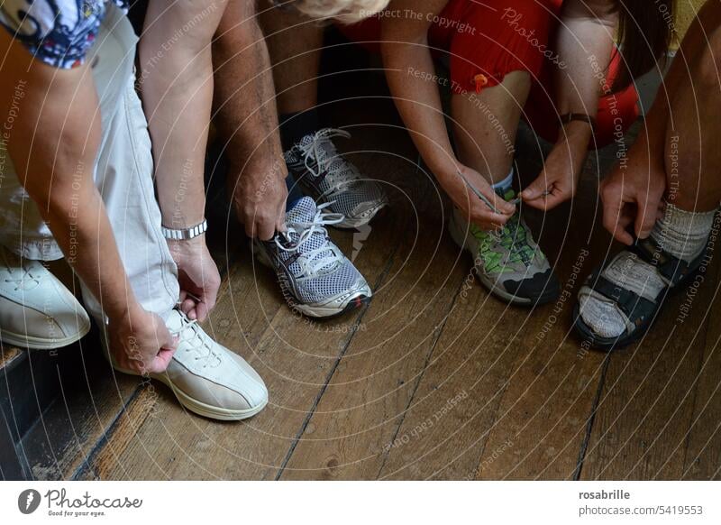 Let's go - group of people get ready and lace up their shoes loose on up and running On your marks, get set, go set out take off Ready Footwear put on shoes