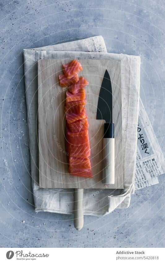 Sliced raw salmon on wooden stand at served table sushi prepare poke cutting board healthy fish meal lunch appetizing fresh appetizer tasty cuisine culinary