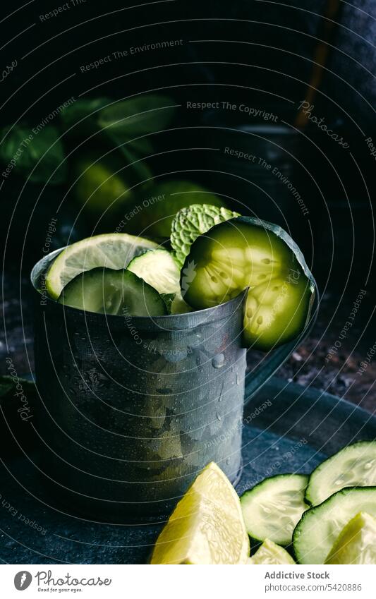 Cucumber detox drink with mint and lime cucumber ingredient table lemon cold mug tray dark fresh healthy natural citrus fruit composition cup arrangement