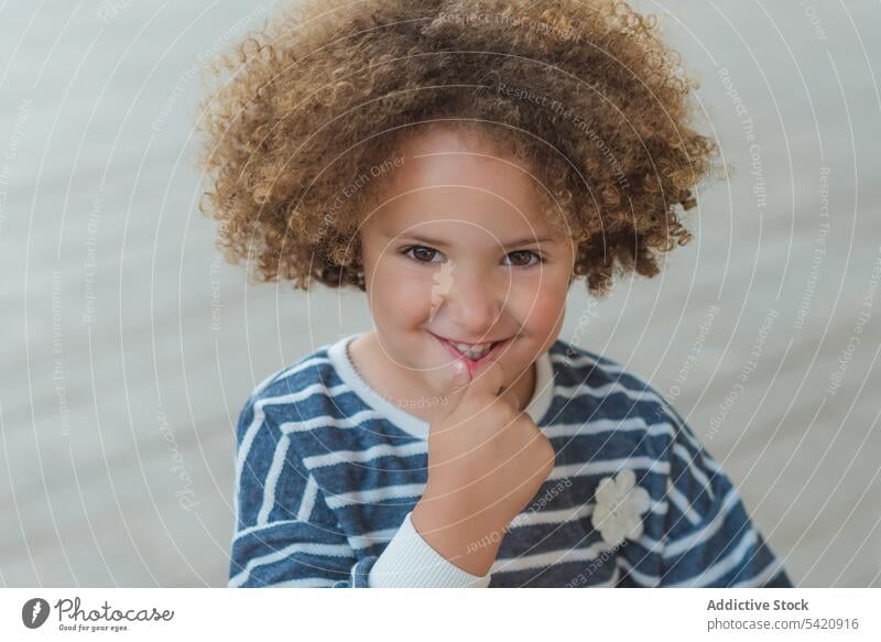 Happy ethnic little girl on street cheerful happy cute kid curly hair child adorable smile trendy casual joy childhood positive charming fun content innocent