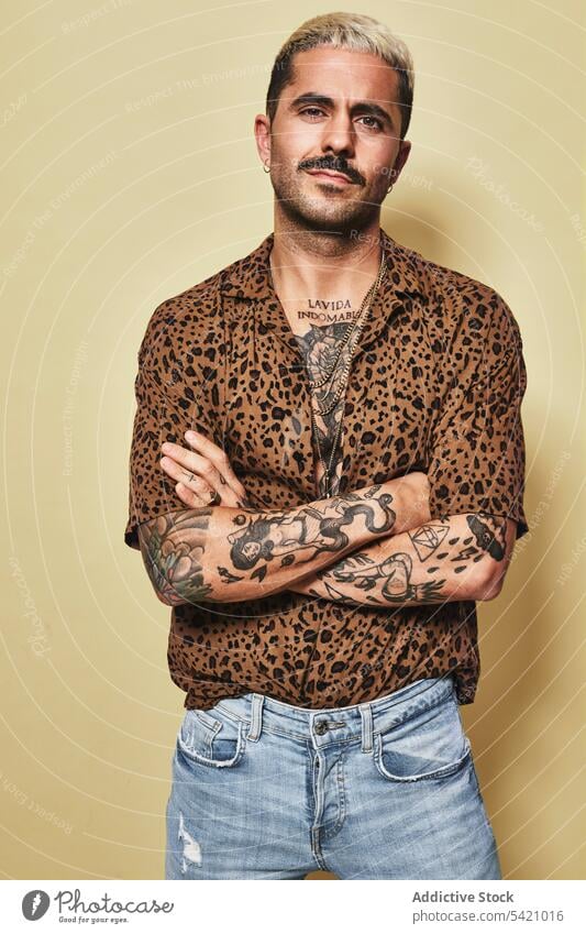 Trendy ethnic guy in stylish outfit standing in studio man trendy style fashion leopard coat model jeans beard male cloth modern cool confident handsome