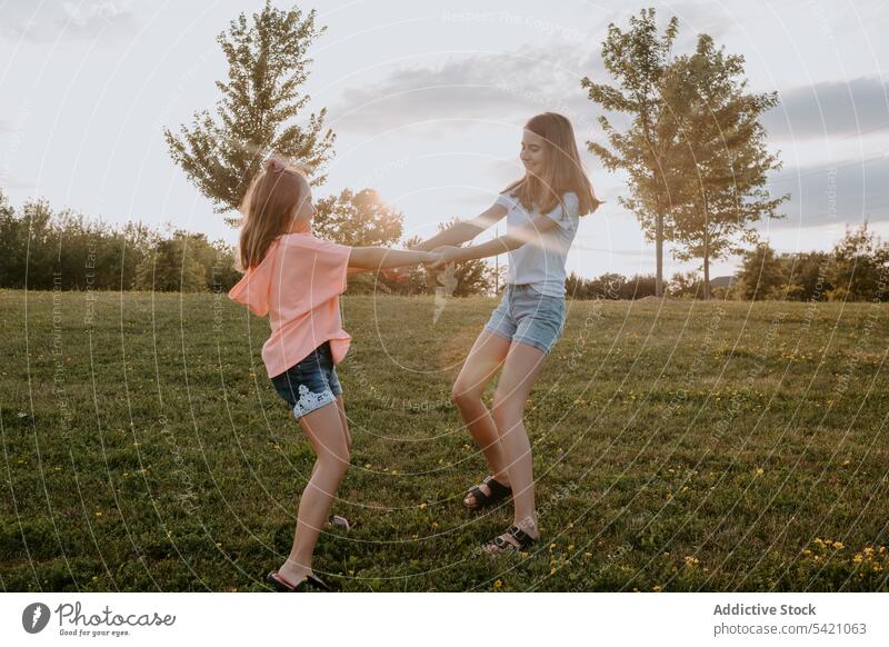 Happy sisters having fun in summer countryside kid nature together happy girl cheerful run teen teenage green meadow sibling friend smile relationship field joy