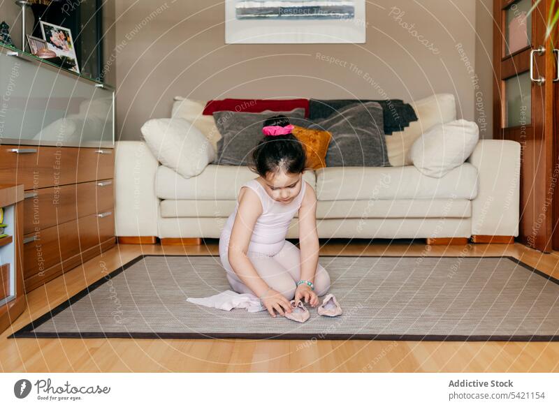 Little ballerina putting on dance shoes little girl ballet put on home rehearsal prepare sit floor living room sofa carpet cute leotard tights dancer child kid