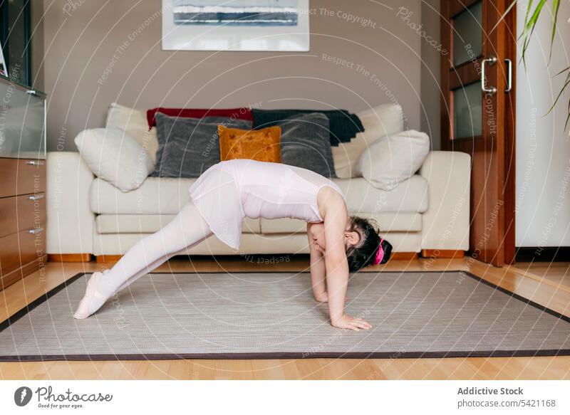 Little ballerina exercising in living room girl exercise dance home floor rehearsal cozy little kid workout ballet dancer child stretch bend gymnastic warm up