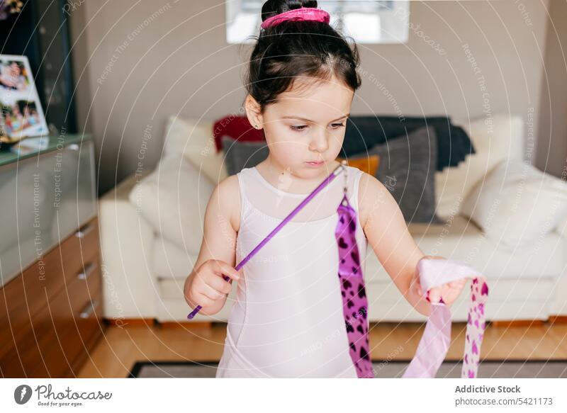 Little gymnast exercising with ribbon at home girl gymnastic dance rehearsal rhythmic spin training little leotard living room child dancer childhood perform