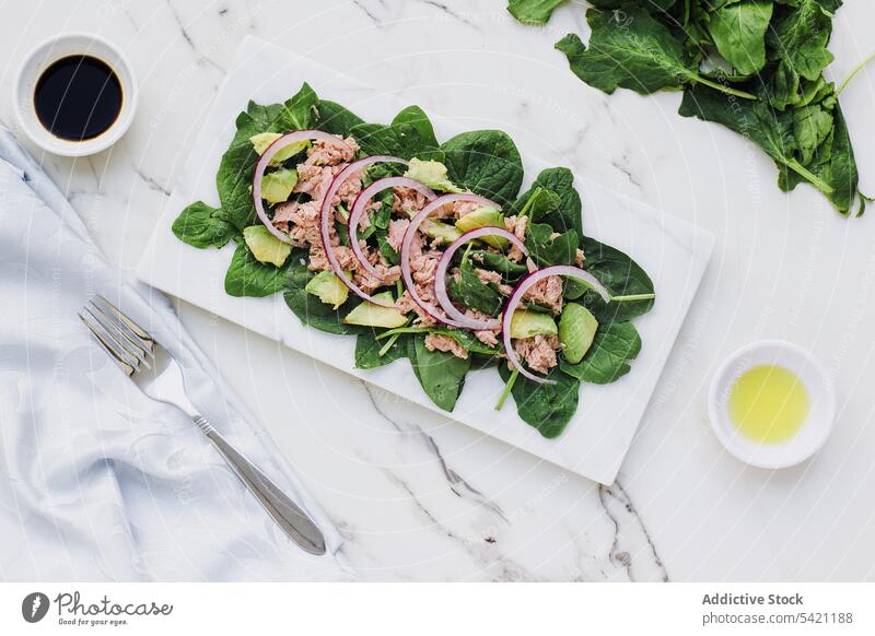 Delicious salad with tuna and fresh greens on marble table avocado onion delicious healthy spinach dinner vegetable food dish meal seasoning balsamic vinegar