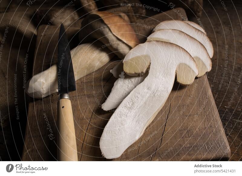 Sliced porcini mushrooms and knife on table boletus edulis cep slice cut fresh raw edible fungus organic food natural nutrition rustic ingredient vegan