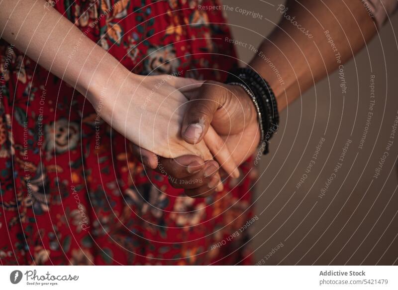 Loving multiracial couple holding hands romantic love together relationship affection close fondness unity multiethnic diverse black bracelet accessory date