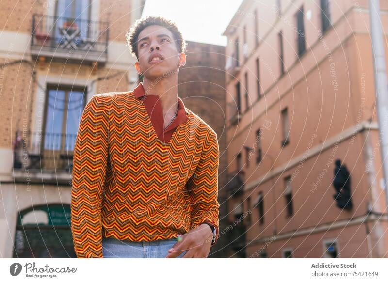 Thoughtful stylish ethnic man in colorful shirt style trendy thoughtful fashion pensive stripe outfit modern young male curly hair afro confident handsome