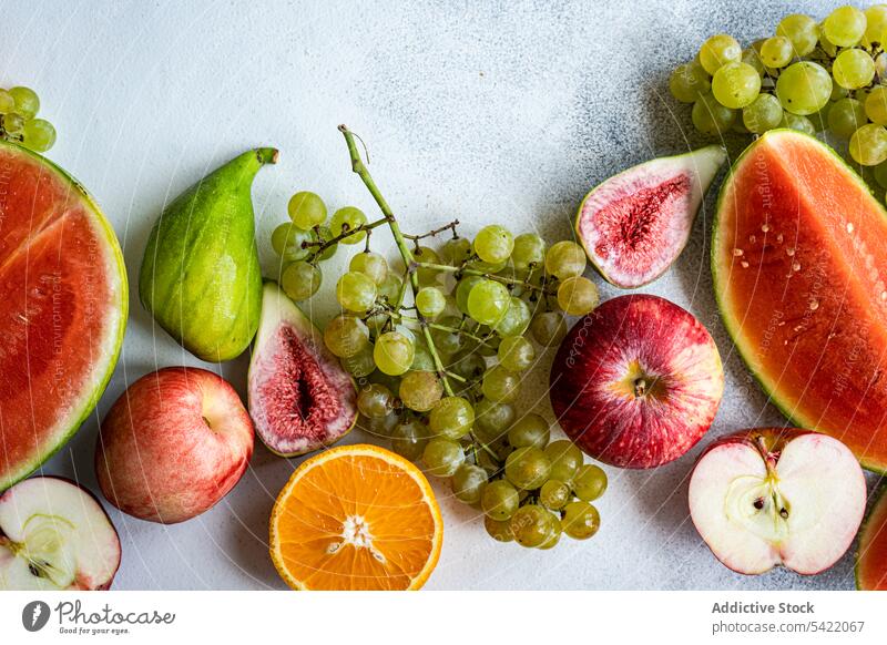 Seasonal fruit frame on white surface seasonal high angle from above watermelon grape apple cut fresh food organic colorful design decoration set healthy