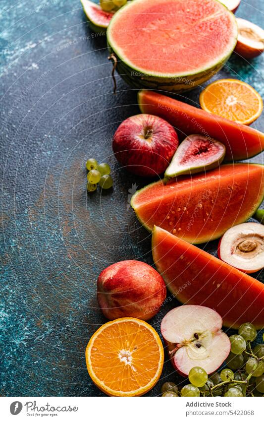 Seasonal fruit frame on dark surface seasonal high angle from above blur watermelon grape apple cut fresh food organic colorful design decoration set healthy