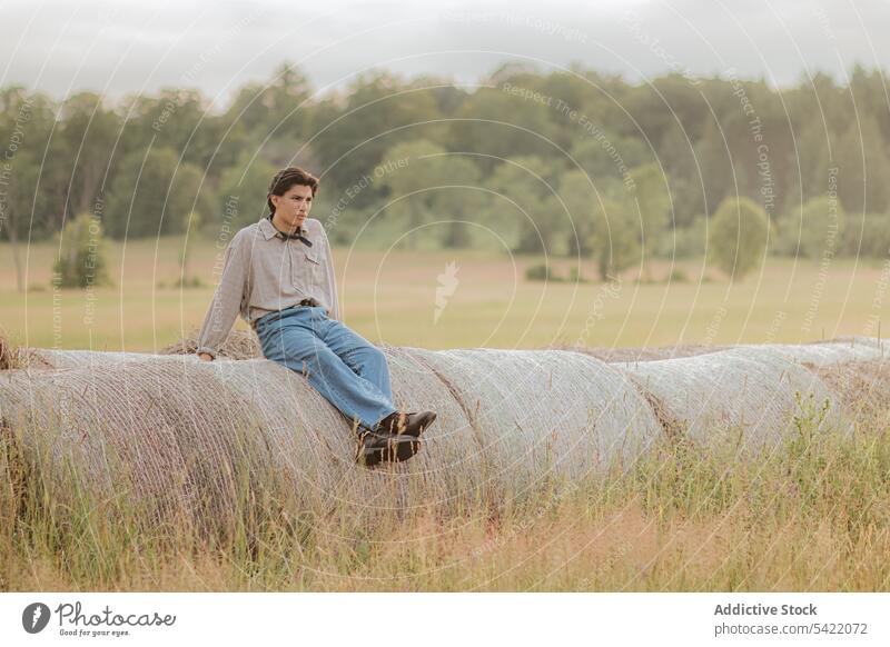 Pensive man sitting in grassy valley traveler mountain rest peace alone solitude nature thoughtful relax lifestyle tourism pensive journey serious male hiker