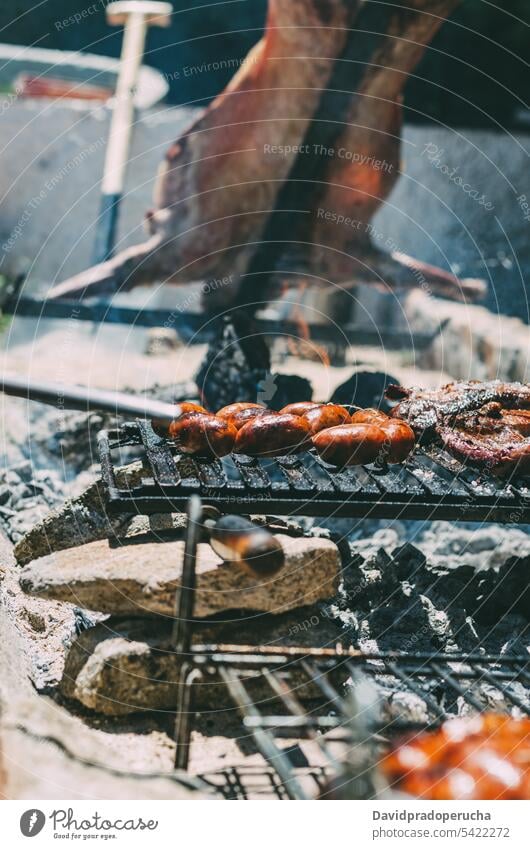 Lamb roasting in a barbecue lamb roasted grilled ribs meat animal chop charcoal chourizo food bbq cooking cuisine embers stick summer outdoor fire whole hot