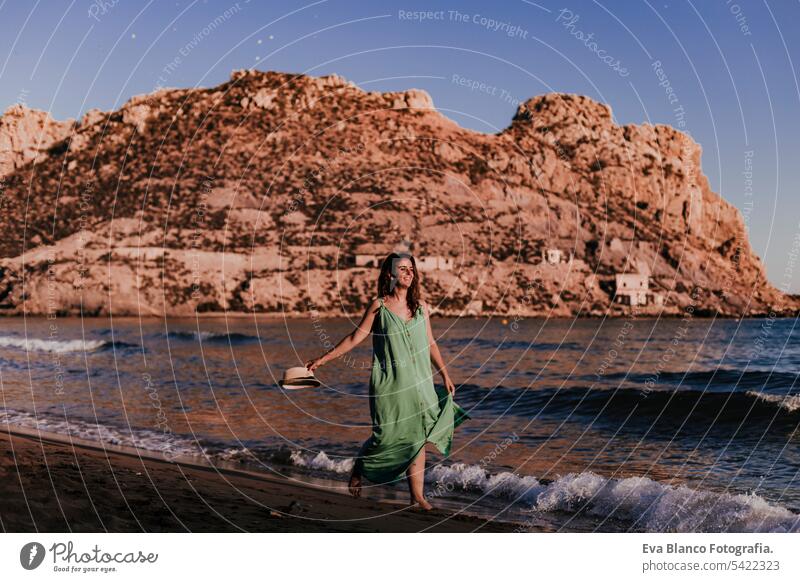 young beautiful woman walking by the beach at sunset. Relax and holidays concept cute model shore fresh light tourism motion sunlight shine freedom romantic