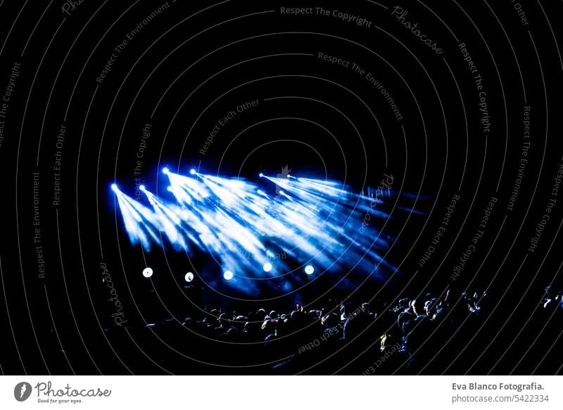 Picture of a lot of people enjoying night perfomance, large unrecognizable crowd dancing with raised up hands and mobile phones on concert. nightlife fan live