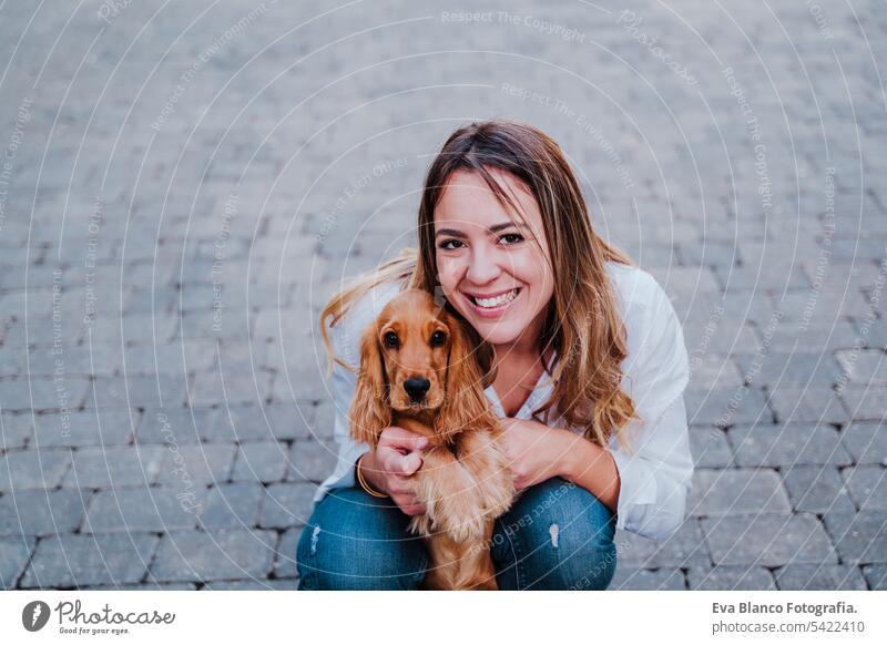 young woman at the street hugging her cute cocker dog. Lifestyle outdoors with pets friendship city beautiful walking smile animal outside leisure sun companion