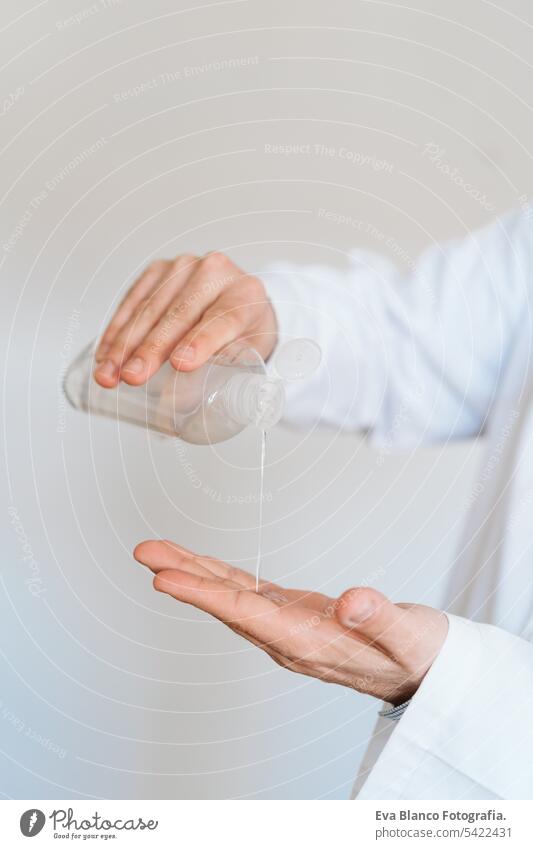 caucasian doctor wearing protective mask and gloves indoors. Using an alcohol gel or antibacterial disinfectant. Hygiene and corona virus concept man