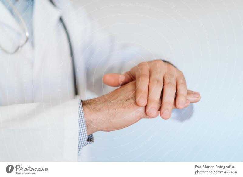 caucasian doctor wearing protective mask and gloves indoors. Using an alcohol gel or antibacterial disinfectant. Hygiene and corona virus concept man