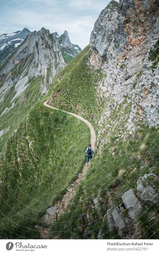 Woman hiking on path in swiss mountains Vantage point Panorama (View) Mountain Sky Clouds Alpstein hiking country appenzellerland Appenzell Grass stones Rock