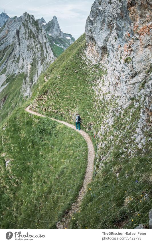 Woman hiking on path in swiss mountains Vantage point Panorama (View) Mountain Sky Clouds Alpstein hiking country appenzellerland Appenzell Grass stones Rock