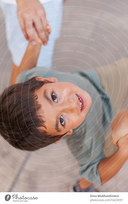 kid looking to the camera, holding hands with his parents, closeup portrait. View from above. boy child Child Boy (child) Portrait photograph Infancy young one