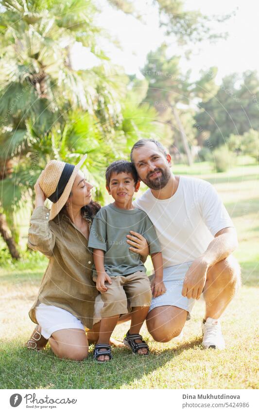 happy family smiling with a son in park outdoors in summer mom dad father mother parenthood parents fatherhood motherhood love together child childhood bonding