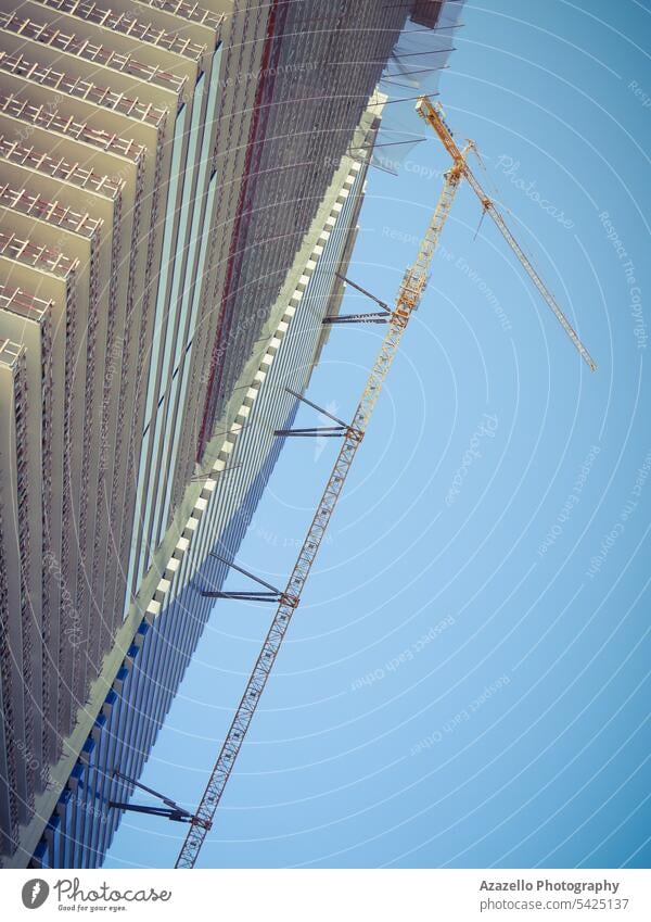 Modern unfinished skyscraper with a lifting crane. apartment architectural architecture background balcony block building business cement city cityscape