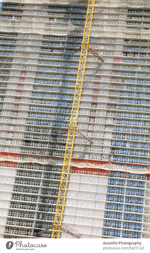 Modern unfinished skyscraper with a lifting crane. apartment architectural architecture background balcony block building business cement city cityscape