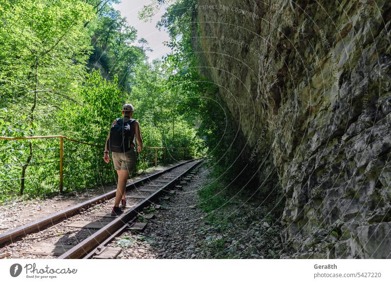 young woman tourist walks on the railway in the jungle of thailand adventure backpack climate fitness forest freedom fresh girl go green health hiking journey