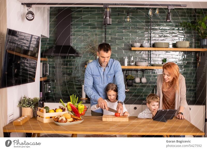 Young family preparing vegetables in the kitchen caucasian happy mother girl daughter woman young father cute childhood home healthy son children day adult